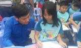 Bí thư T.Ư Đoàn, Chủ tịch Hội đồng Đội T.Ư Nguyễn Long Hải động viên các em nhỏ vẽ tranh tại ngày hội.