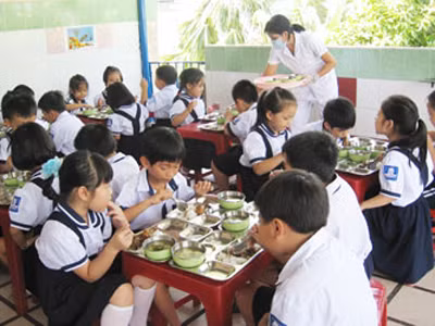 HS lớp 1 bán trú của Trường Tiểu học Kim Đồng đang ăn trưa tại trường. Trường đang lo lắng sẽ khó tổ chức cho HS bán trú như thế này trong năm học tới. Ảnh: Phạm Anh