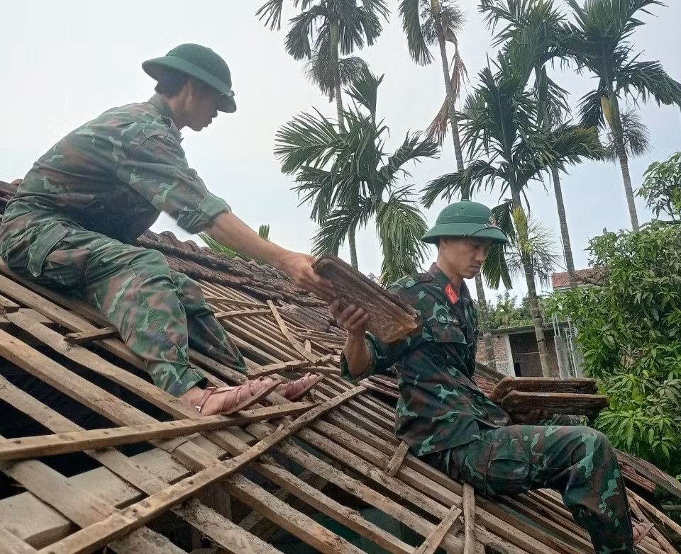 Bộ đội giúp dân lợp lại mái nhà bị tốc mái. Bộ đội giúp dân lợp lại mái nhà bị tốc mái.