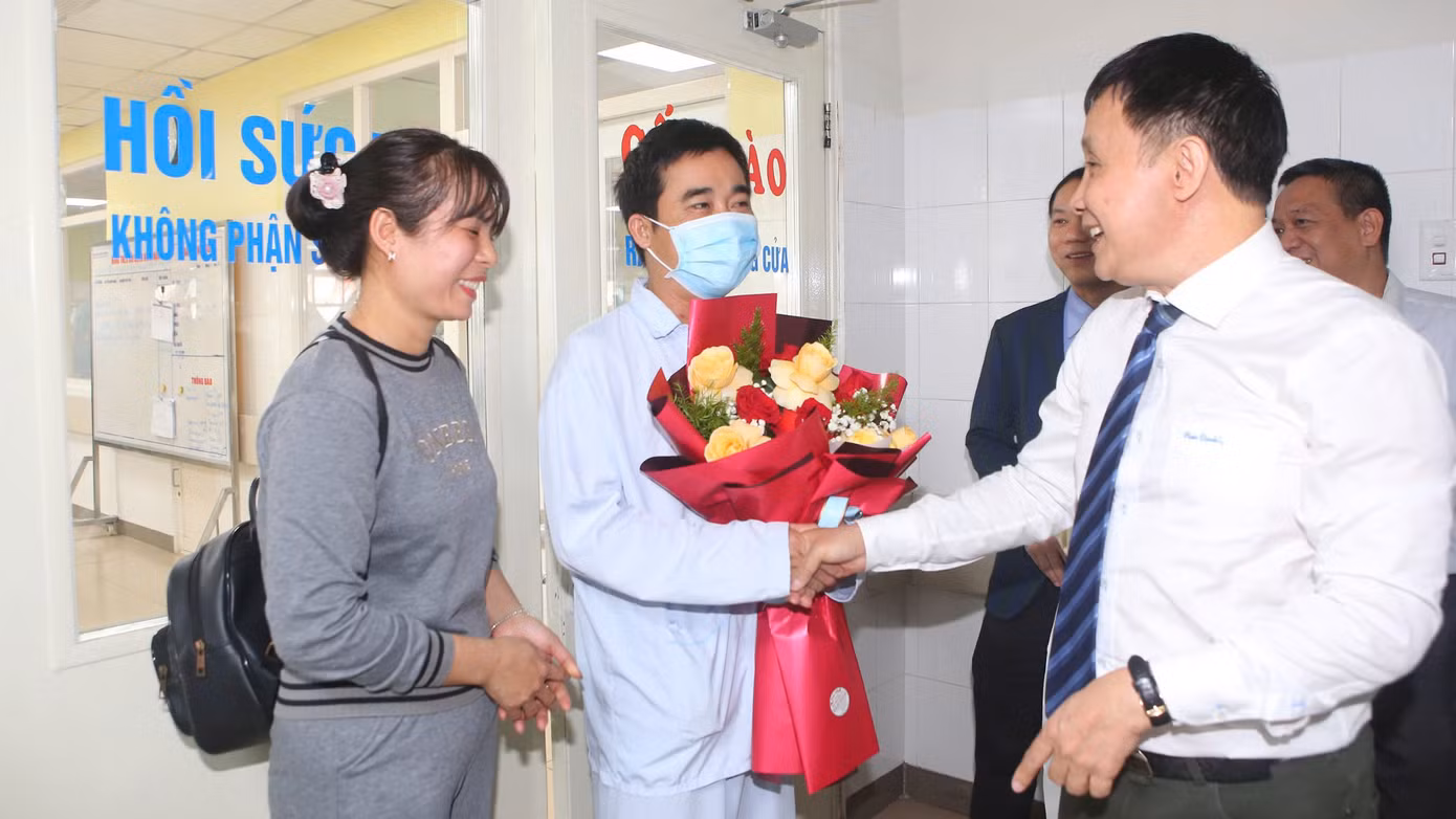 GS.TS Phạm Như Hiệp - Giám đốc Bệnh viện Trung ương Huế, tặng hoa chúc mừng, dặn dò anh N.T.T trong ngày bệnh nhân xuất viện.