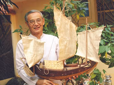 Tiến sĩ Nguyễn Nhã với chiếc ghe bầu mô hình mà các đội dân binh được triều đình cử đi quản lý khai thác Hoàng Sa thế kỷ 19. Ảnh: N.A 