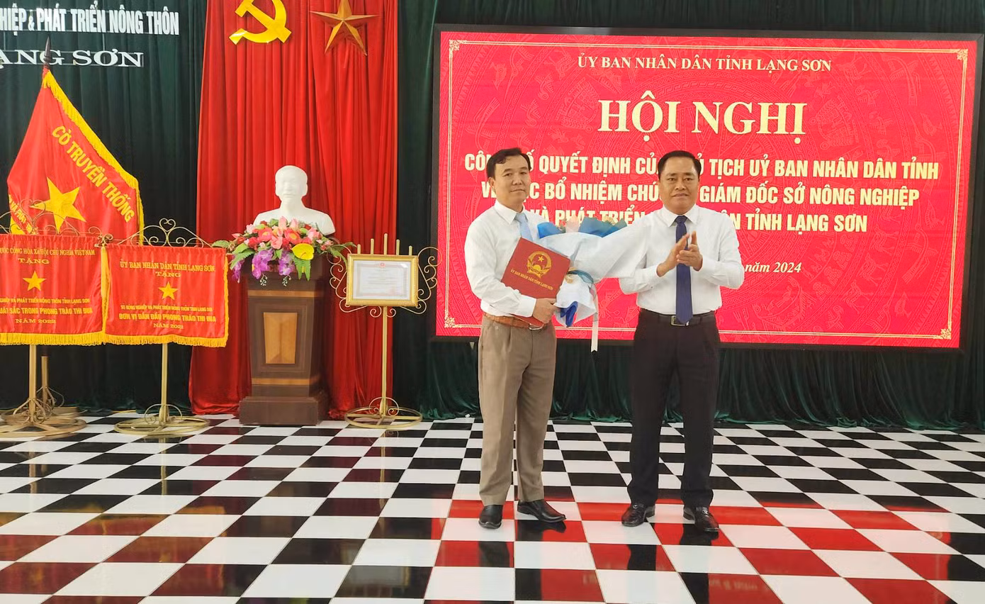 Ông Nguyễn Hữu Chiến (bìa trái) nhận quyết định, hoa chúc mừng của lãnh đạo tỉnh Lạng Sơn. Ảnh: Duy Chiến.