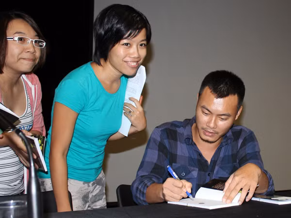 Nguyễn Thế Hoàng Linh ký tặng thơ độc giả tối 20-9. Ảnh: Cúc Chi. Nguyễn Thế Hoàng Linh ký tặng thơ độc giả tối 20-9. Ảnh: Cúc Chi