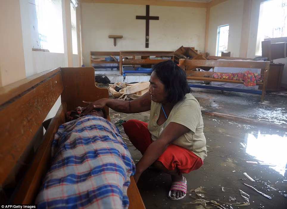 Bà mẹ Philippines ngôi trong một nhà thờ bị tan hoang sau cơn bão, bên cạnh thi thể của người con trai. Bà đã khóc cạn nước mắt vì mất con, mất nhà cửa do bão Haiyan 
