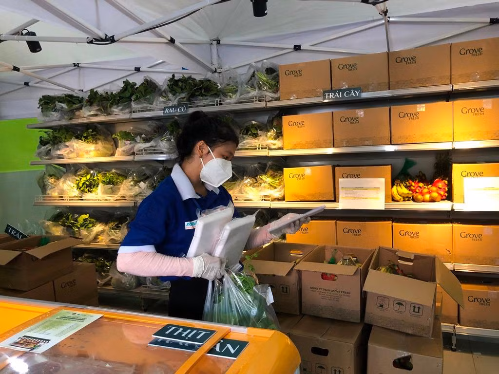 Phó Bí thư Đoàn phường Cô Giang (quận 1) Trần Thị Thùy Linh đi chợ hộ giúp dân