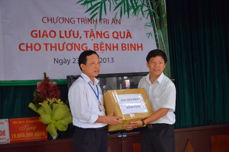 Phó Tổng Biên tập báo Tiền Phong, ông Trần Thanh Lâm (phải) trao quà của báo tới Trung tâm.