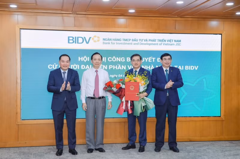 Phó Thống đốc thường trực NHNN Đào Minh Tú, Phó Bí thư Đảng ủy khối DNTW Hồ Xuân Trường trao Quyết định và chúc mừng ông Đặng Văn Tuyên (ảnh: SBV).