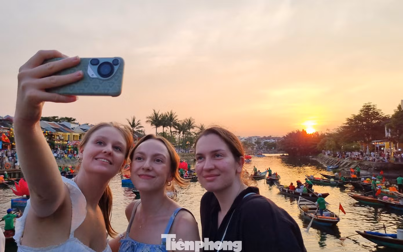 Nhóm du khách nước ngoài bắt trọn khoảnh khắc hoàng hôn nơi phố cổ Hội An. Ảnh: Hoài Văn.