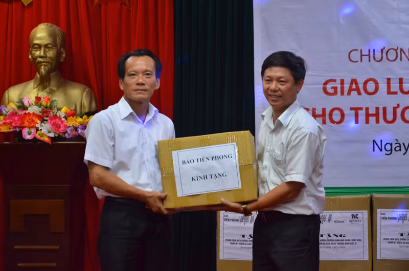 Phó tổng Biên tập báo Tiền Phong Trần Thanh Lâm (phải) trao quà của báo tới Trung tâm