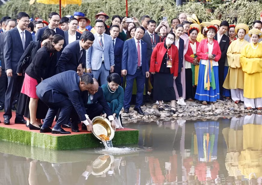 Chủ tịch nước Nguyễn Xuân Phúc và Phu nhân cùng các đại biểu kiều bào thả cá chép tiễn ông Công, ông Táo theo phong tục truyền thống tại Hồ sen trong Khu di tích Hoàng Thành Thăng Long. (Ảnh: Thống Nhất/TTXVN) Chủ tịch nước Nguyễn Xuân Phúc và Phu nhân cùng các đại biểu kiều bào thả cá chép tiễn ông Công, ông Táo theo phong tục truyền thống tại Hồ sen trong Khu di tích Hoàng Thành Thăng Long. (Ảnh: Thống Nhất/TTXVN)