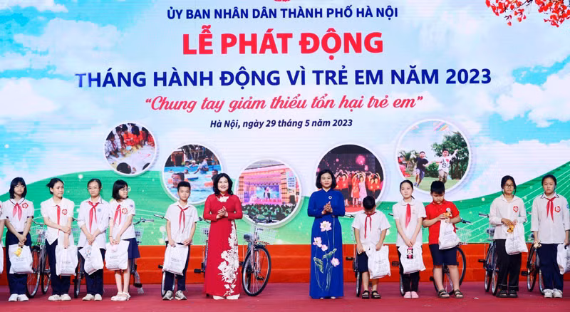 Bà Nguyễn Thị Tuyến, Phó Bí thư Thường trực Thành ủy Hà Nội (áo dài xanh) và lãnh đạo Bộ LĐ,TB&amp;XH trao quà cho các học sinh có hoàn cảnh khó khăn