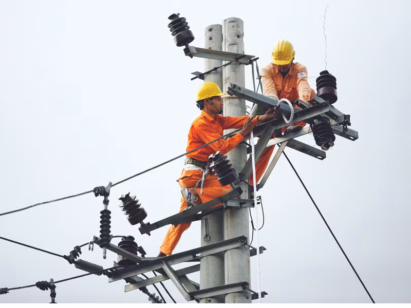 Công nhân điện lực đang thi công mạng lưới điện tại cầu Vĩnh Tuy (Hà Nội). Ảnh: Xuân Phú