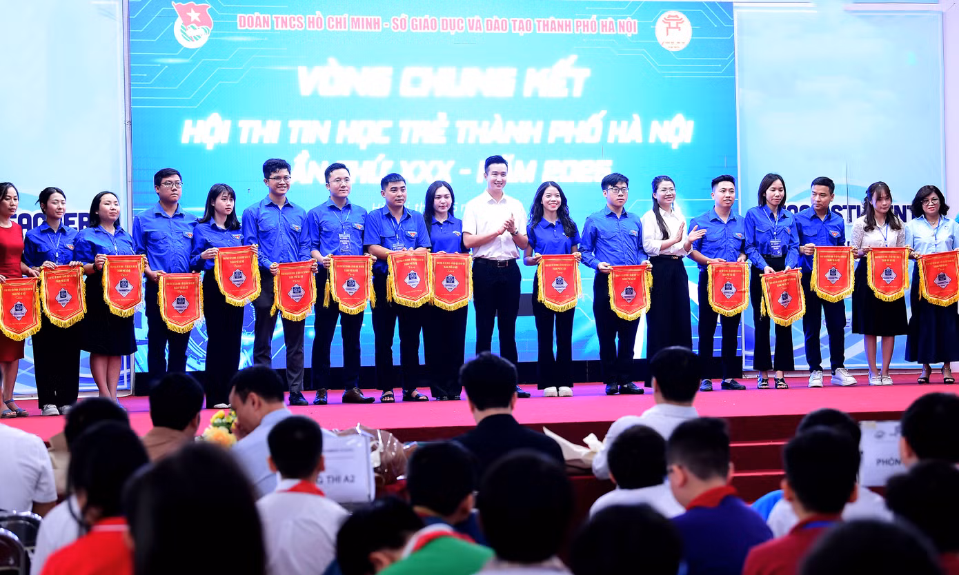 Anh Đào Đức Việt trao tặng cờ lưu niệm cho các đơn vị tham gia Hội thi Tin học trẻ thành phố Hà Nội năm 2025. Ảnh: Xuân Tùng