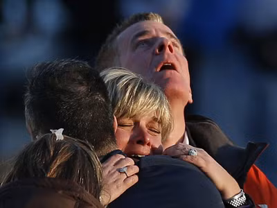 Gia đình nạn nhân đau khổ gần trường Sandy Hook. Ảnh: GETTY IMAGES