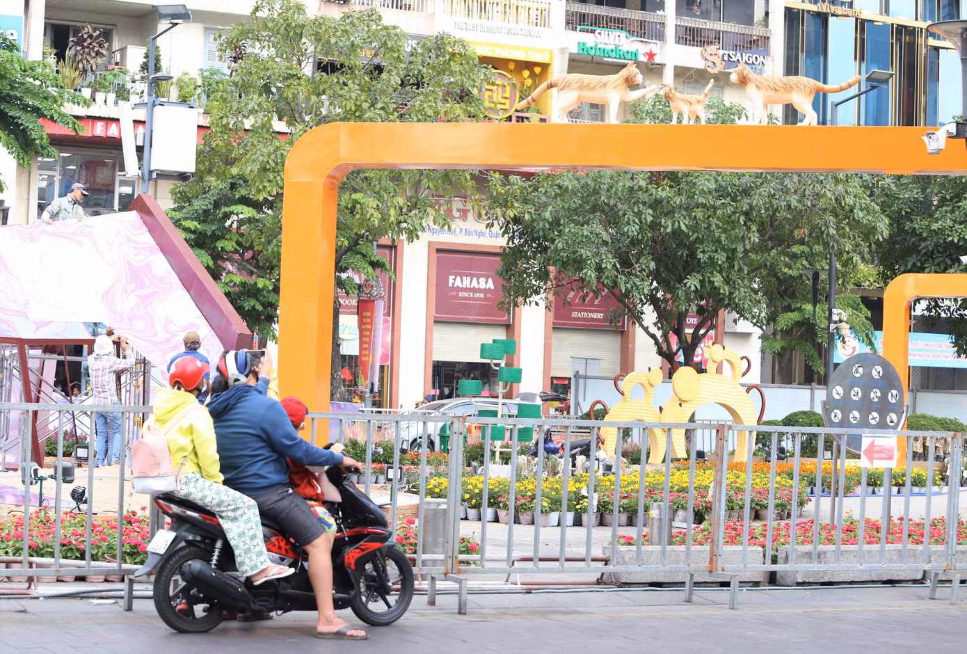 Một gia đình trẻ tranh thủ ghi hình không gian đường hoa khi đi ngang qua Phố đi bộ Nguyễn Huệ.
