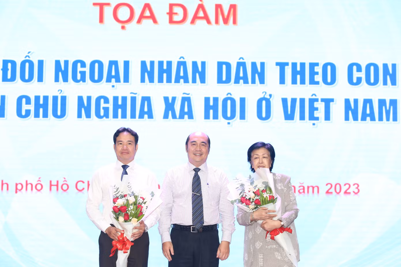 Lãnh đạo HUFO tặng hoa cám ơn những chia sẻ của hai diễn giả tại tọa đàm. Ảnh: Ngô Tùng