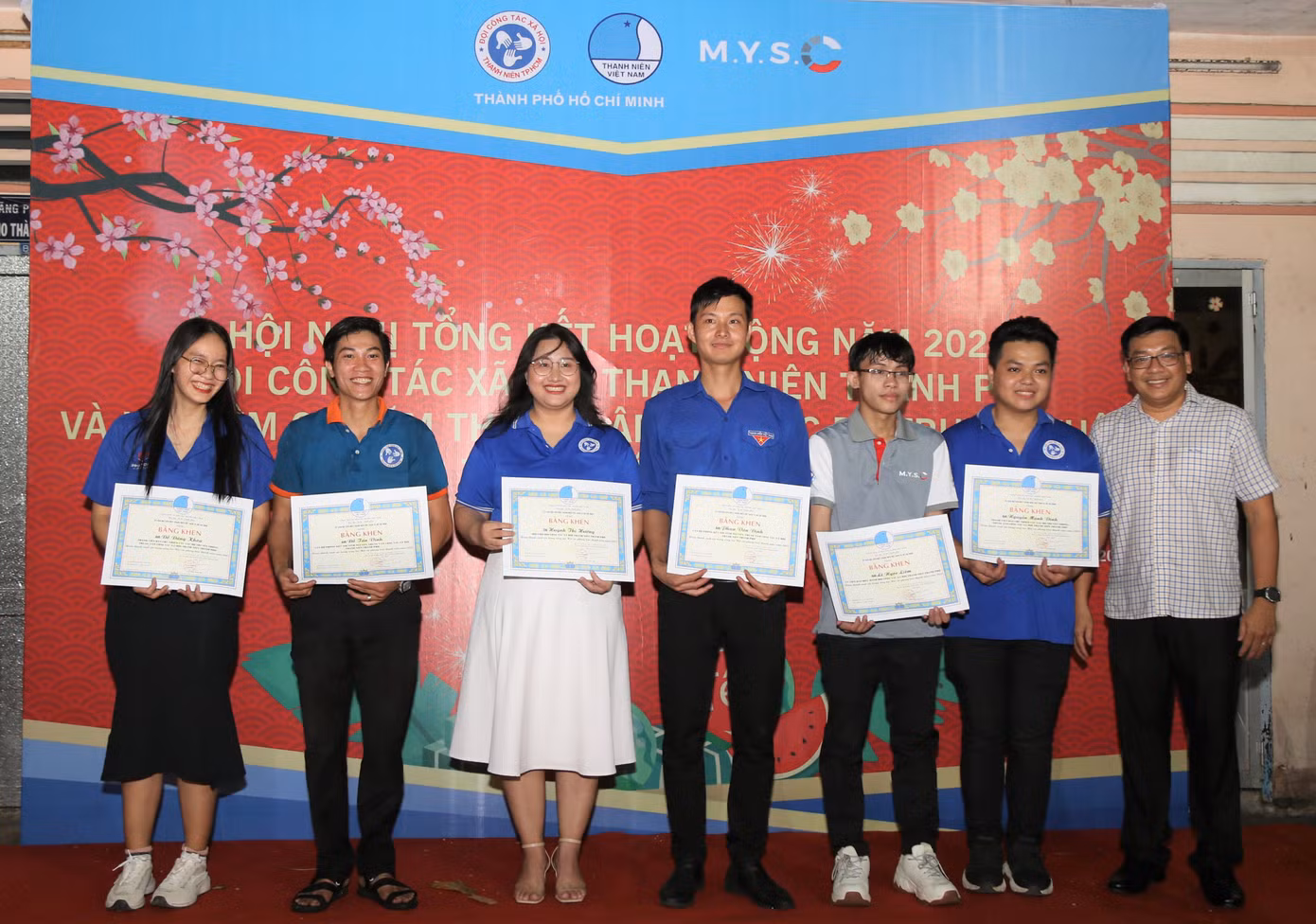 Giám đốc Trung tâm CTXH thanh niên TPHCM Dương Ngọc Tuấn (bìa phải) trao giấy khen cho các bạn tình nguyện viên tiêu biểu.