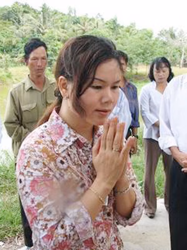 Bích Hằng đang thắp hương trước ngôi mộ cô Khang. Bích Hằng đang thắp hương trước ngôi mộ cô Khang