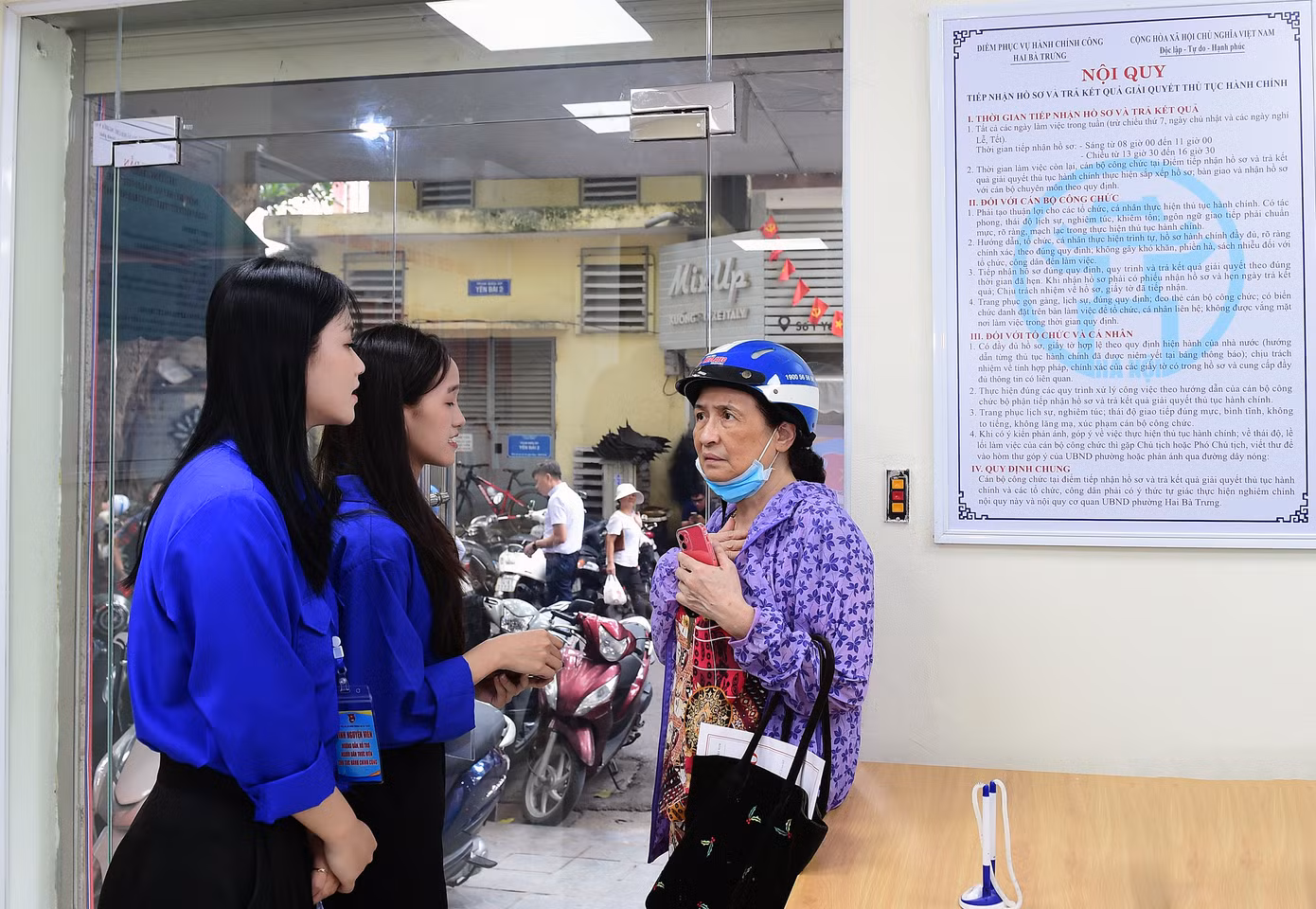Huyền Nga và đồng đội tham gia hỗ trợ tiếp đón, hỗ trợ đăng ký số cho người dân đến làm thủ tục hành chính ở phường Hai Bà Trưng. Ảnh: Xuân Tùng