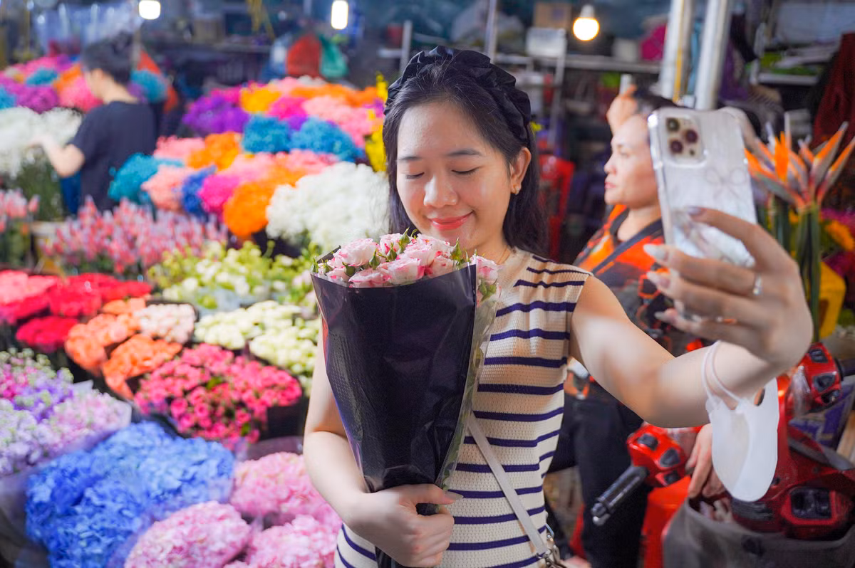 Chị Liên (quận Thanh Xuân, thành phố Hà Nội) đứng nép vào một quầy hoa để tự chụp ảnh kỷ niệm cho bản thân. “Là phụ nữ, tự dành tặng cho mình bó hoa vào dịp này cũng ý nghĩa mà, quan trọng là niềm vui và hạnh phúc".