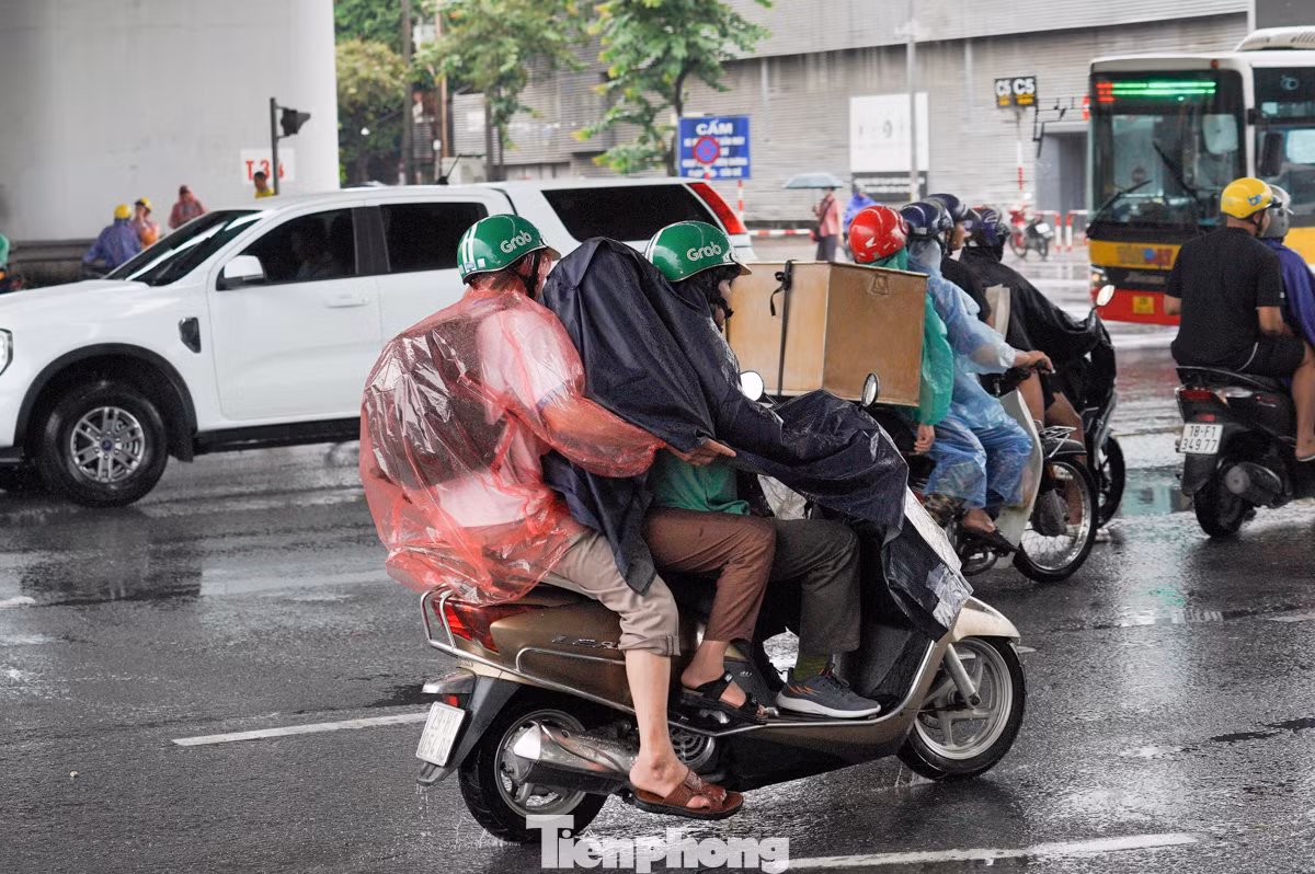 Trời mưa khiến việc ra bến xe trở nên khó khăn trong lớp áo mưa.