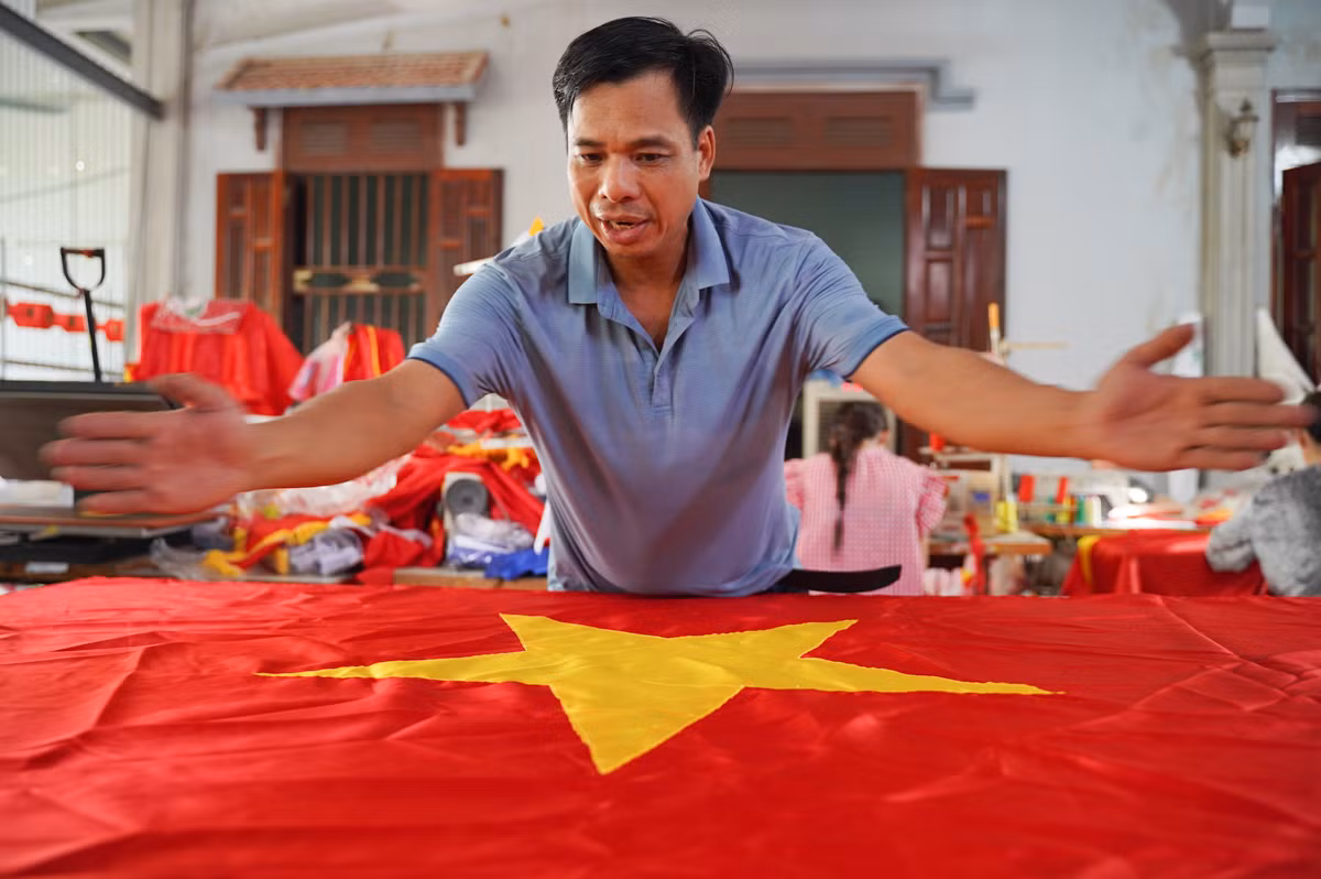Chia sẻ với Tiền Phong, ông Nguyễn Văn Phục - một trong những hộ kinh doanh lâu năm tại làng Tứ Vân cho biết, thị trường cờ năm nay đang rất sôi động, đặc biệt gần ngày 2/9. Tại cơ sở của ông, các nhân viên phải tăng ca để đáp ứng đủ nhu cầu của thị trường. "Từ việc cắt vải theo nhiều kích thước khác nhau, đến in hình ngôi sao, thêu và may hoàn thiện... mỗi công đoạn đều được chúng tôi thực hiện tỉ mỉ, chứa đựng tâm huyết của người dân làng nghề", ông Phục nói.