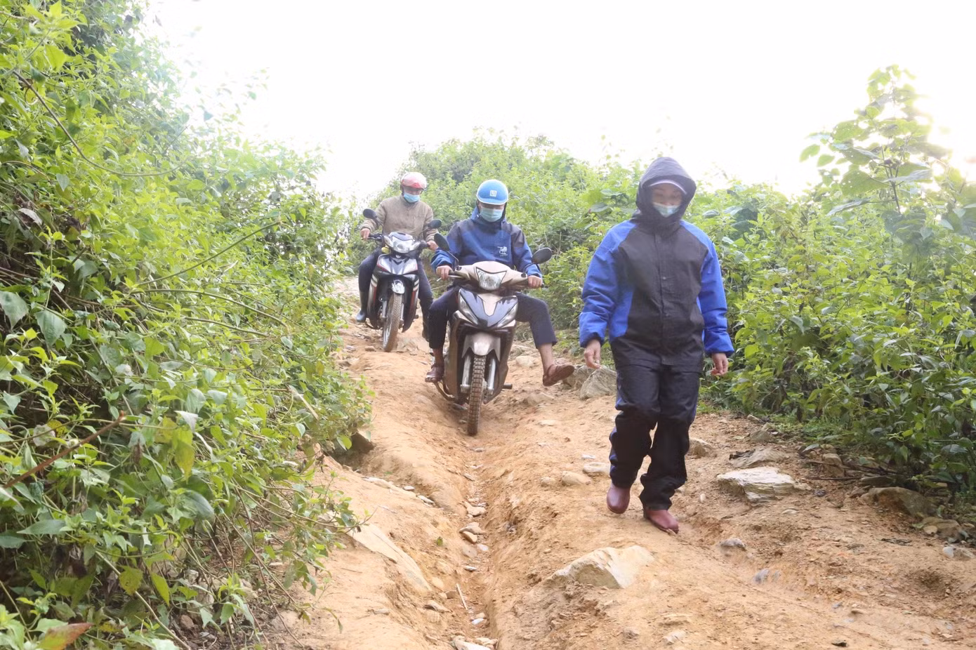 Con đường mòn khúc khuỷu, đất đá lởm chởm, quanh co giữa núi đồi, nhiều đoạn dốc đứng cheo leo, vực thẳm