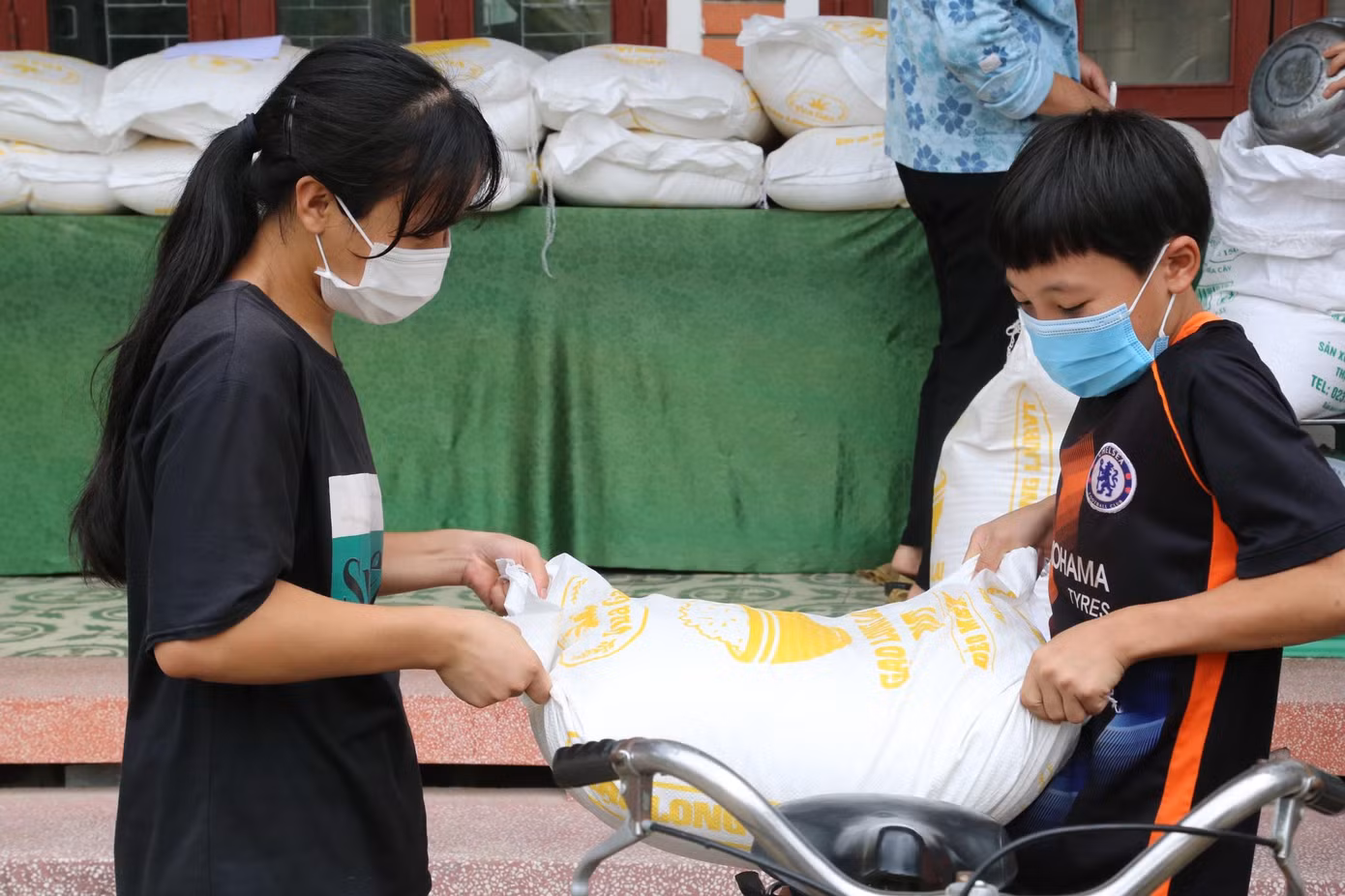 Các em nhỏ ở Làng trẻ em SOS Vinh nhận gạo của nhà hảo tâm hỗ trợ