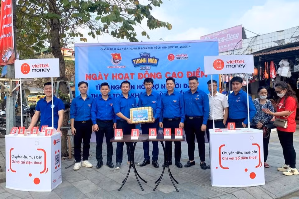 Cấp tỉnh, thăm, tặng quà các đội hình tình nguyện, tổ hỗ trợ chuyển đổi số cộng đồng tại chợ Quán Lau, bộ phận một cửa Công an tỉnh, chợ Hưng Dũng, Trung tâm Phục vụ hành chính công tỉnh, chợ Quán Hành, Bộ phận một cửa Công an huyện Nghi Lộc. Trong ảnh, anh Vũ Minh Thảo – Uỷ viên BCH, Phó Ban Thanh niên Nông thôn Trung ương Đoàn cùng Ban Thường vụ Tỉnh Đoàn Nghệ An tặng quà cho đội thanh niên tình nguyện tham gia hỗ trợ người dân đăng ký tài khoản và thanh toán trực tuyến qua ví điện tử Viettel Money tại chợ Quán Lau, Thành phố Vinh.