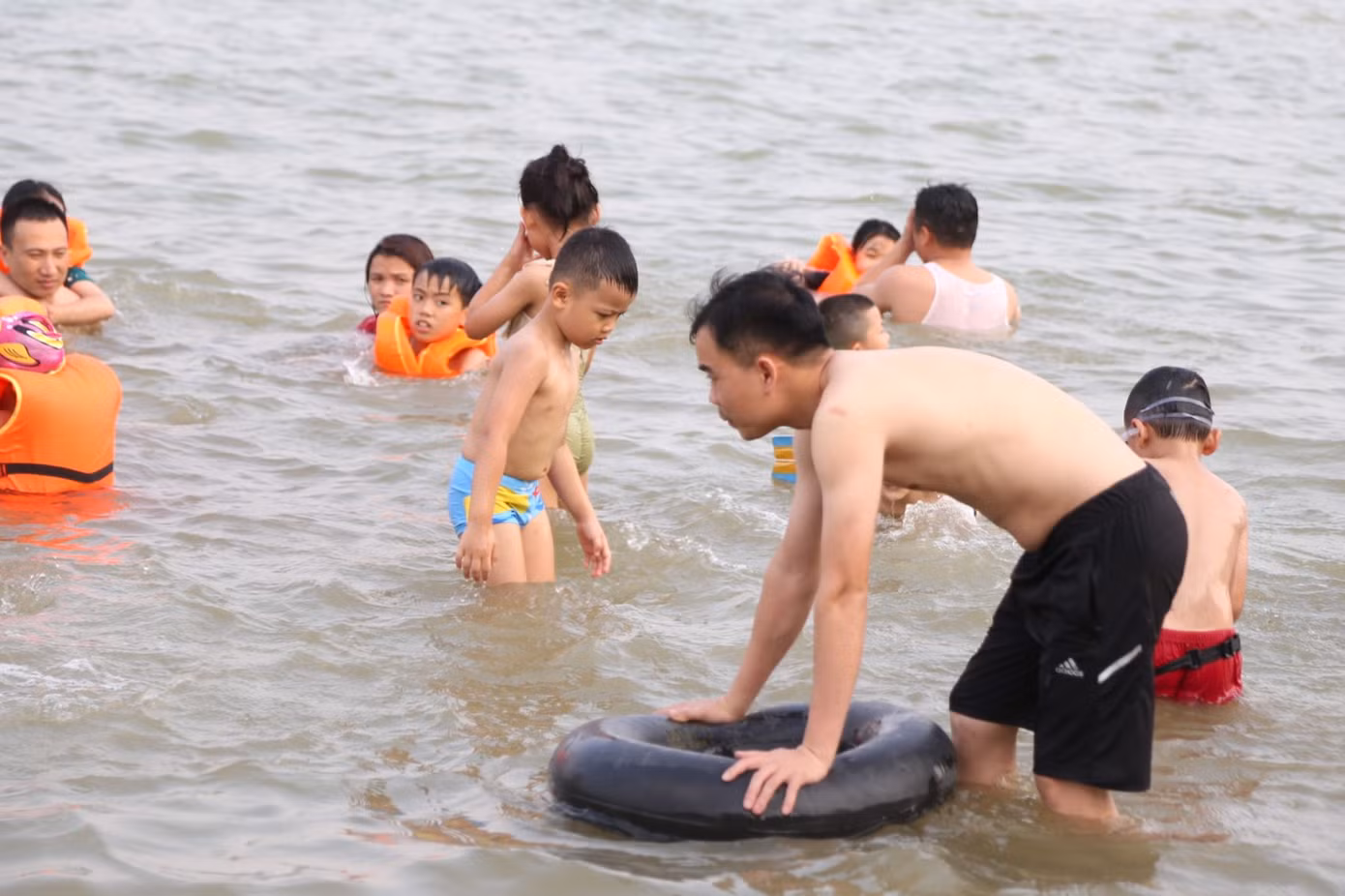 Các em nhỏ được trang bị áo phao, kính lặn, tắm cùng người lớn để đảm bảo an toàn.