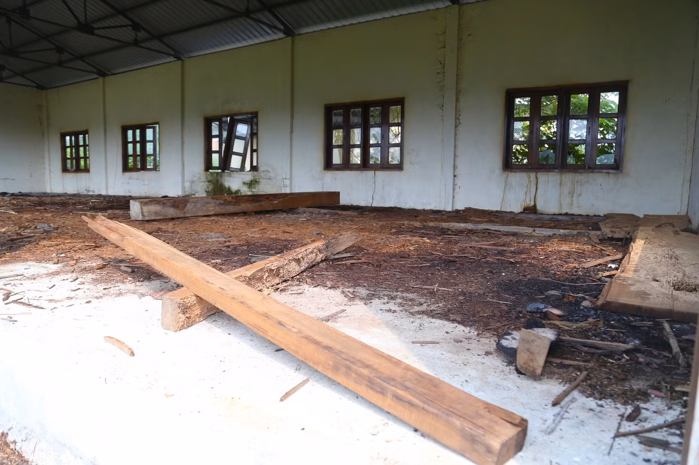 Bên trong một dãy nhà, mùn cưa, gỗ tạp ngổn ngang.