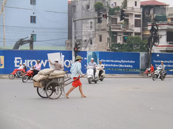 Hoàng Anh Việt kéo xe chở 6 bao xi măng. Ảnh: Trường Phong