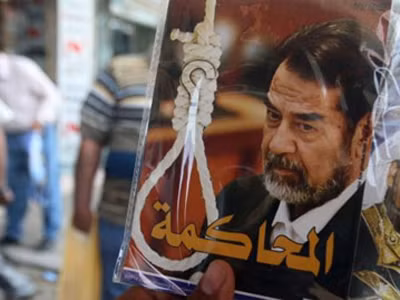 Một người bán hàng rong chìa CD về vụ xét xử cựu Tổng thống Iraq Saddam Hussein. Ảnh: PressTV
