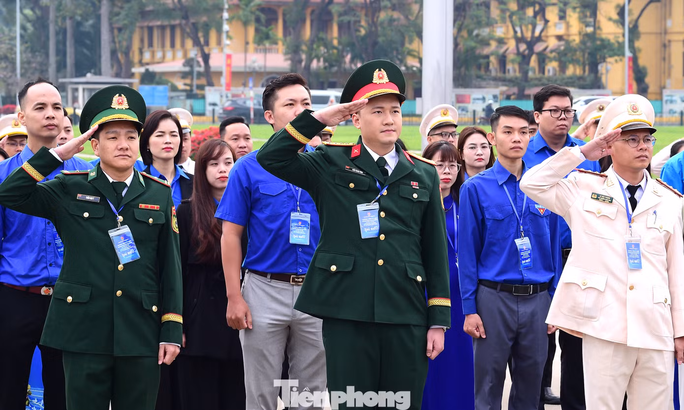 Các đại biểu nghiêm trang thực hiện nghi thức chào cờ tại lễ báo công dâng Bác. Ảnh: Xuân Tùng