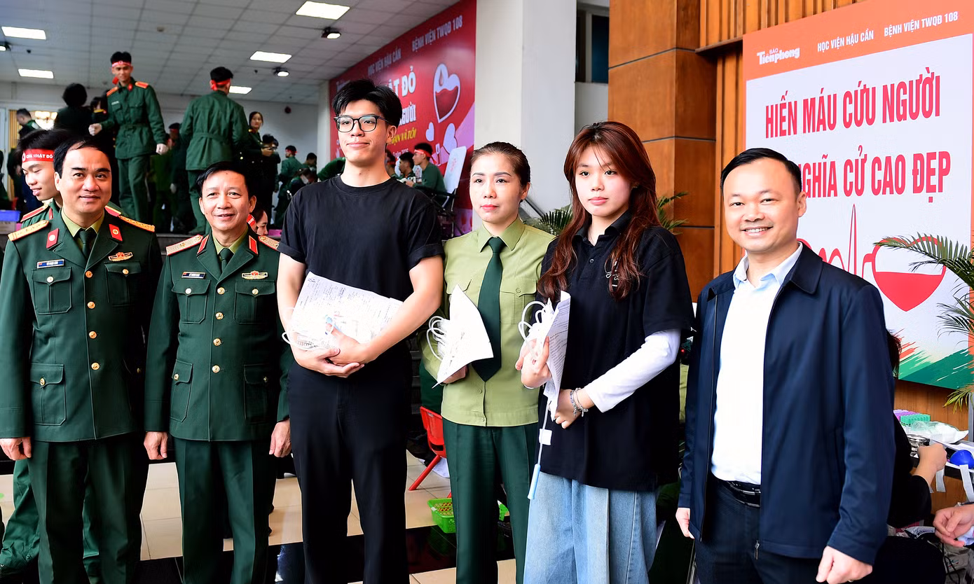 Ban Tổ chức thăm hỏi, động viên và chụp ảnh cùng ba mẹ con chị Phạm Thu Trang - cán bộ công tác tại Học viện Hậu cần, tham gia hiến máu tại chương trình.