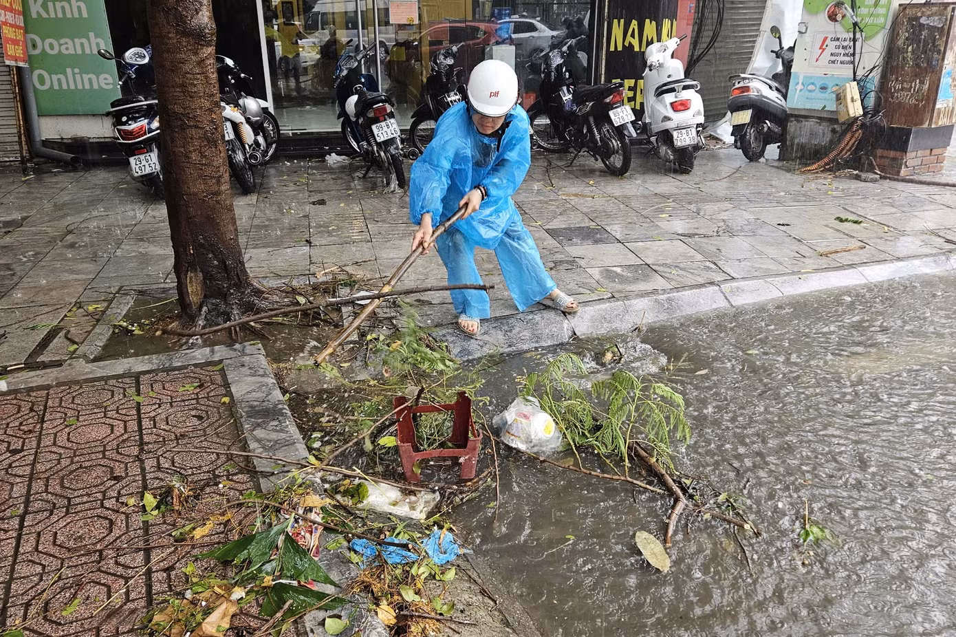 Người dân dọn rác ở miệng cống.
