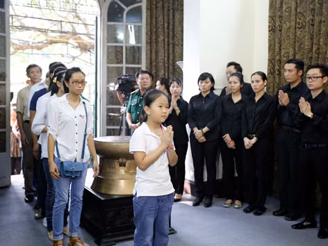 Cháu bé đi cùng với chị gái đến chắp tay thắp hương đại tướng
