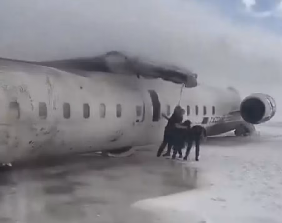 Hành khách được đưa ra khỏi chiếc máy bay lật ngược. Ảnh: Breaking911.