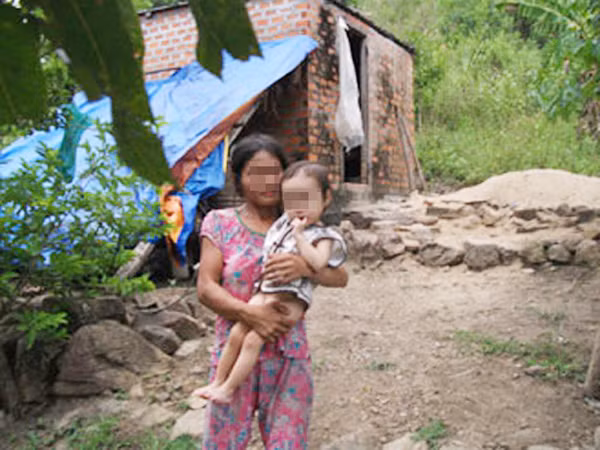 Mẹ con Tam Anh trước căn nhà nhỏ giữa rừng. Ảnh: phapluattp.vn