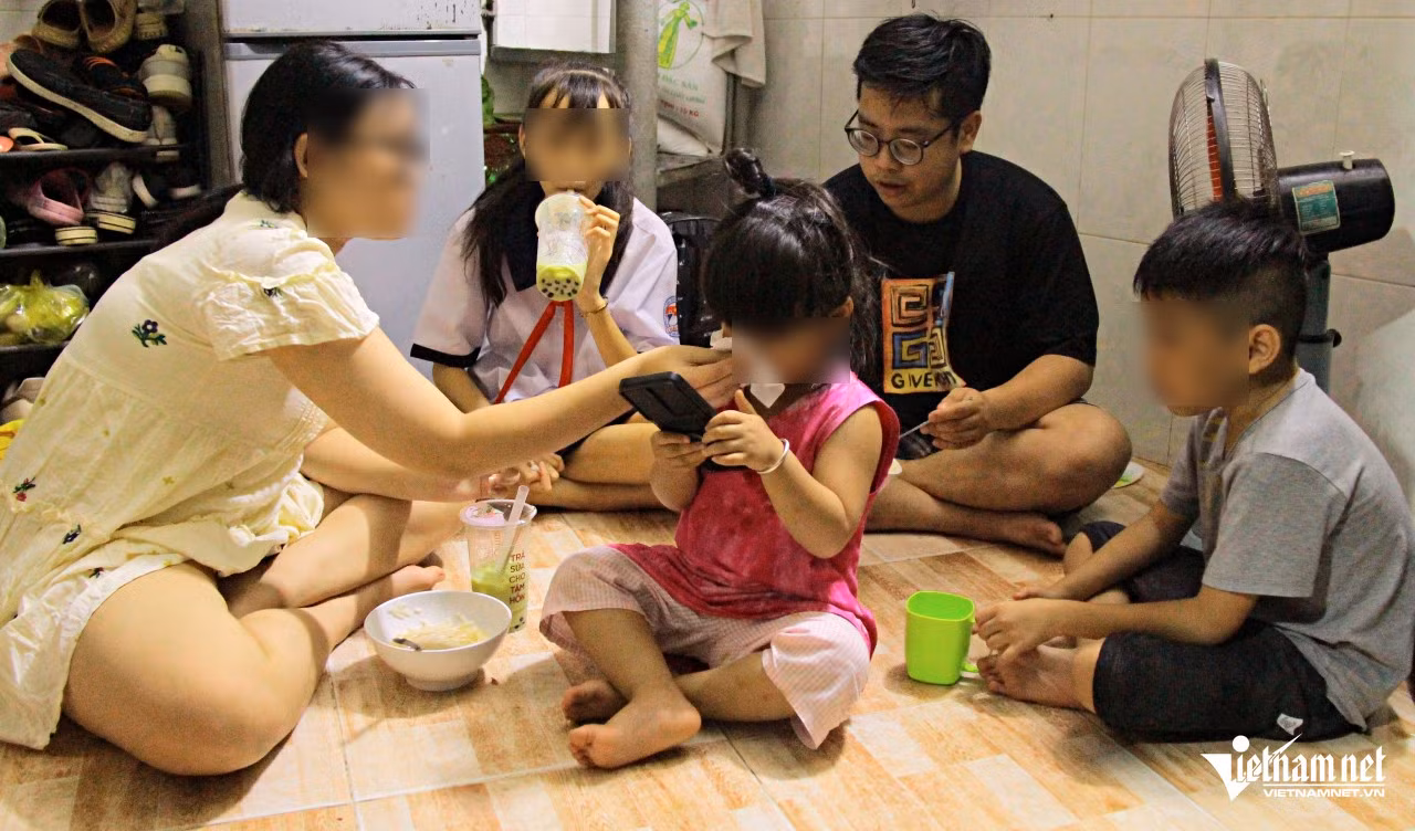Cuối ngày, Hùng Phúc (áo đen) dành ít phút chăm sóc các cháu, rồi ra đường chạy xe ôm công nghệ. Ảnh: Hà Nguyễn