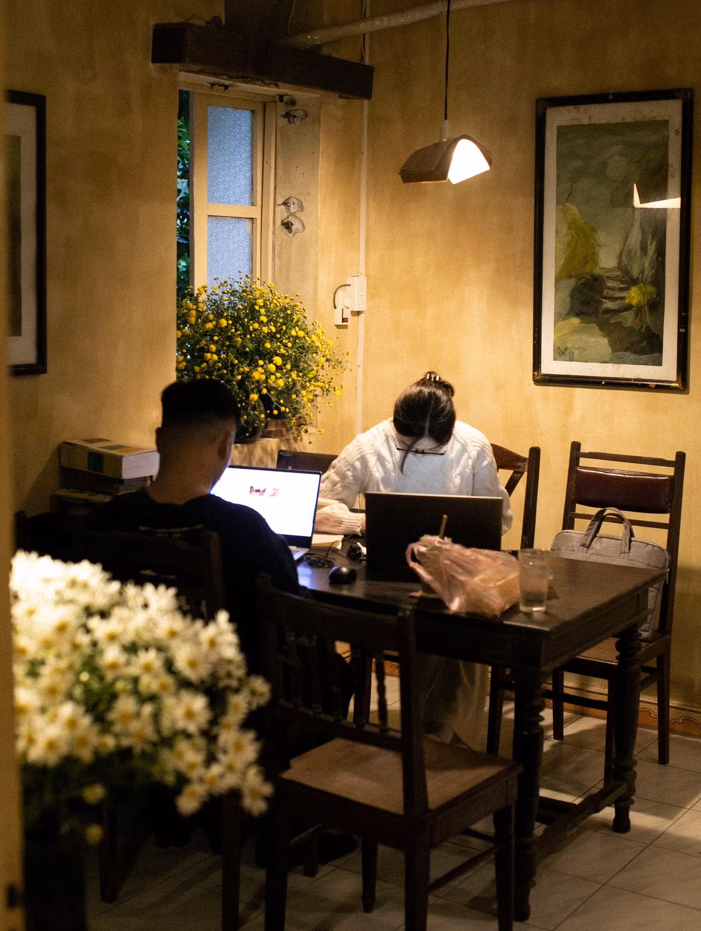 Hai bạn trẻ đang làm việc tại một quán cà phê tại Đống Đa, Hà Nội. (Ảnh: Tiệm Cà Phê Thư Báo)