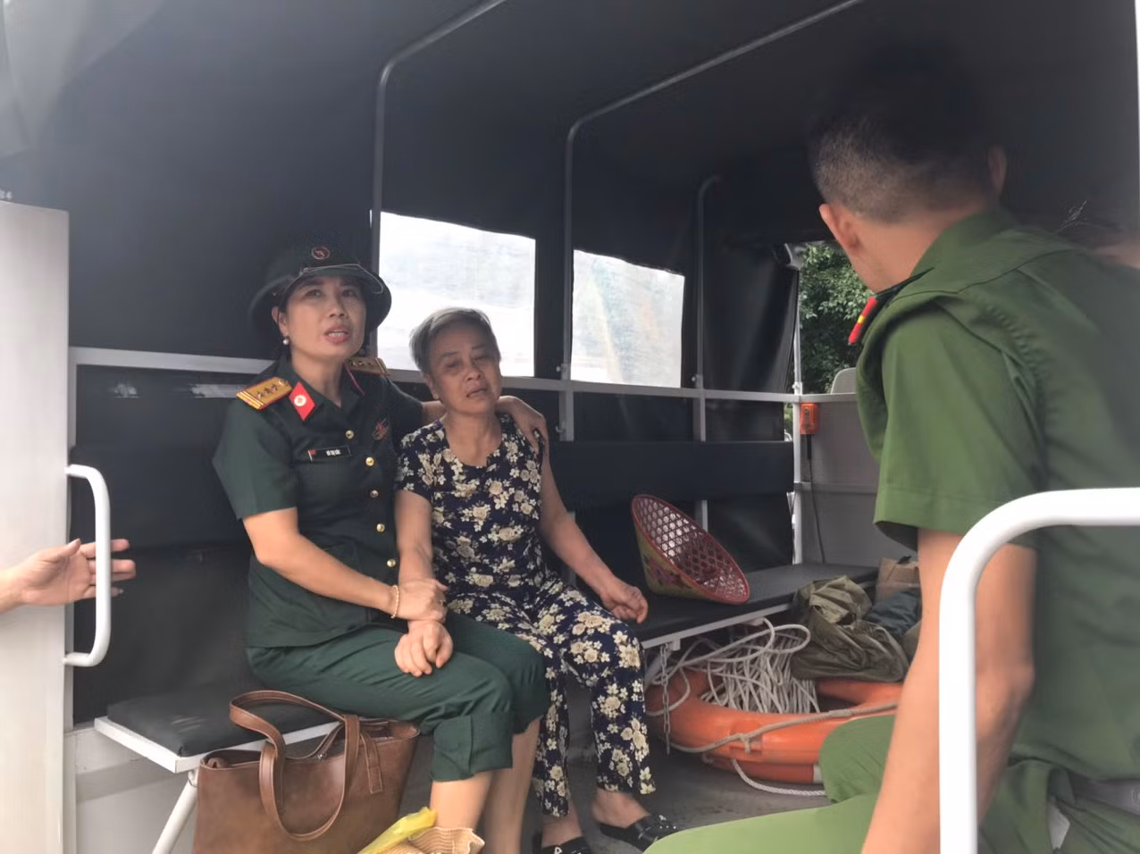 Một cụ già được lực lượng chức năng đưa ra khỏi vùng ngập lụt và di chuyển đến bệnh viện để thăm khám sức khoẻ. Ảnh: Trường Phong