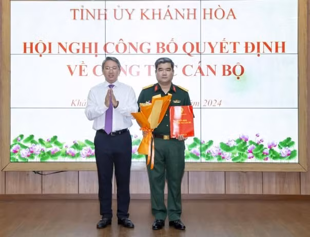 Ông Nguyễn Hải Ninh (ảnh trái) trao quyết định của Ban Bí thư Trung ương Đảng cho Thượng tá Nguyễn Tấn Ý. Ảnh: Báo Khánh Hòa