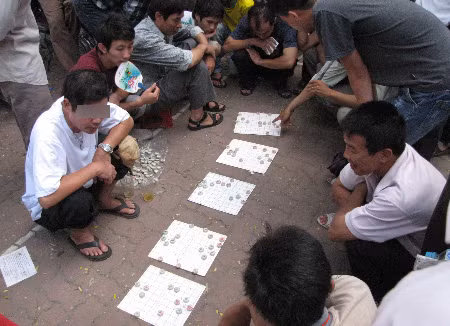 Năm bàn cờ thế ăn tiền trên vỉa hè trước cổng trường Đại học Bách Khoa Hà Nội. Ảnh: Trường Phong.