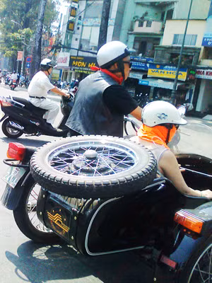 Cặp vợ chồng đi chơi phố trên sidecar độ