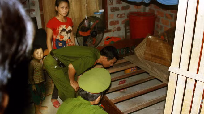 Công an huyện Bố Trạch đang điều tra hiện trường nơi kẻ cướp dùng dao khống chế chị Nga, cướp đi một khúc gỗ sưa - Ảnh: Nguyên Linh (Tuổi Trẻ)