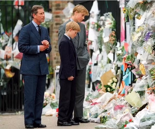Charles, William và Harry xem những bó hoa và thiệp mà công chúng để bên ngoài Cung điện Kensington để bày tỏ lòng thương tiếc Công nương Diana. Ảnh: Anwar Hussein/ Getty.