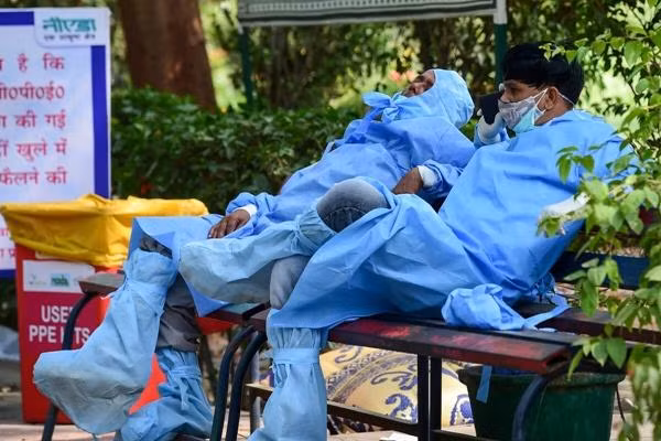 Nhân viên y tế ngồi nghỉ sau khi hỏa táng bệnh nhân COVID-19 ở Noida (Ấn Độ). Ảnh: PTI. Nhân viên y tế ngồi nghỉ sau khi hỏa táng bệnh nhân COVID-19 ở Noida (Ấn Độ). Ảnh: PTI.