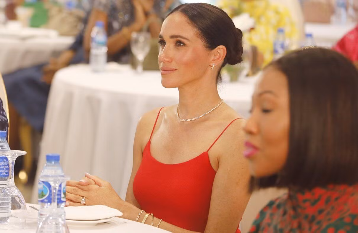 Điểm nhấn trong thời trang của Meghan ở Nigeria là chiếc váy hai dây màu đỏ tại sự kiện Women in Leadership do cô đồng tổ chức cùng Tiến sĩ Ngozi Okonjo-Iweala, Tổng Giám đốc Tổ chức Thương mại Thế giới, ở Abuja vào ngày 11/5. Thiết kế được sáng tạo bởi chuyên gia bản địa Oríré, có giá 332 USD. Đây là chiếc váy có tông màu rực rỡ nhất trong tủ quần áo chủ yếu màu trung tính của Nữ Công tước xứ Sussex. Ảnh: Getty Images.