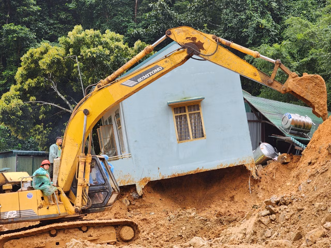 Đêm qua, lực lượng chức năng đã tìm thấy thi thể của 3 cán bộ chiến sỹ CSGT hy sinh. Trưa nay, các lực lượng đã tìm thấy thi thể nạn nhân cuối cùng. Trong ảnh: Một ngôi nhà bị đổ nghiêng bên đường, nhiều đất đá vùi lấp xung quanh. Ảnh: D.P